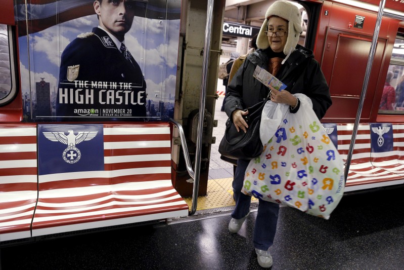 FILE PHOTO: Passengers board a 42nd Street Shuttle subway train, wrapped with advertising for the Amazon series 