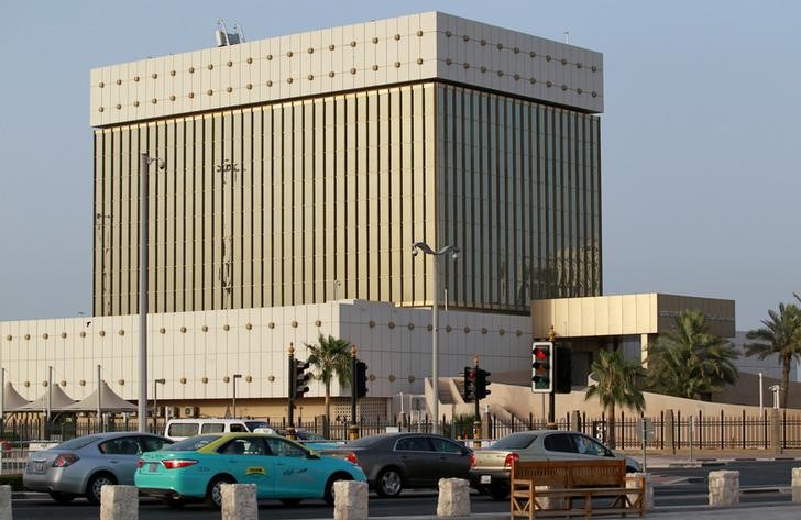 FILE PHOTO: Cars drive past the building of Qatar Central Bank in Doha