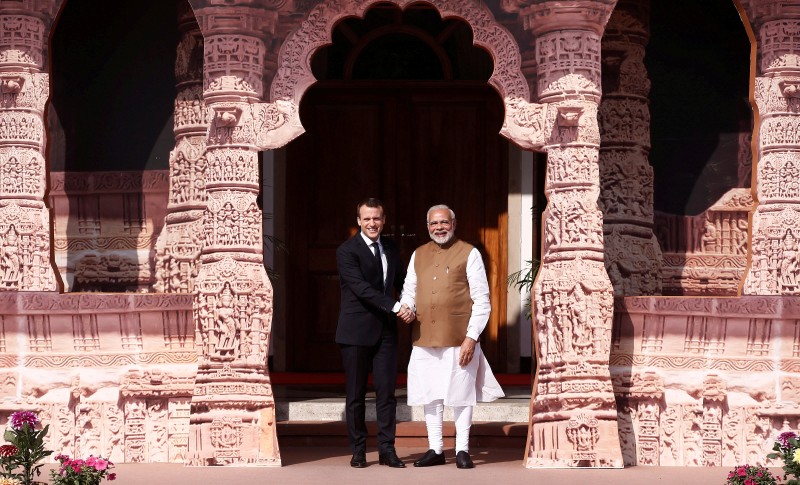 India's Prime Minister Narendra Modi shakes hands with French President Emmanuel Macron as he arrives to attend the International Solar Alliance Founding Conference in New Delhi