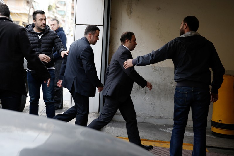 Two of the eight Turkish soldiers, who fled to Greece in a helicopter and requested political asylum after a failed military coup against the government, are escorted by police officers as they arrive at the appeals court in Athens