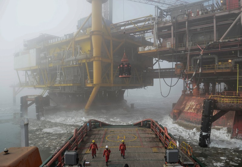FILE PHOTO: Workers are seen on an offshore oil platform in Liaodong bay off Liaoning