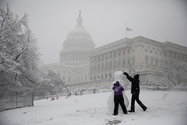 People build a snowman outside the U.S. Capitol in Washington