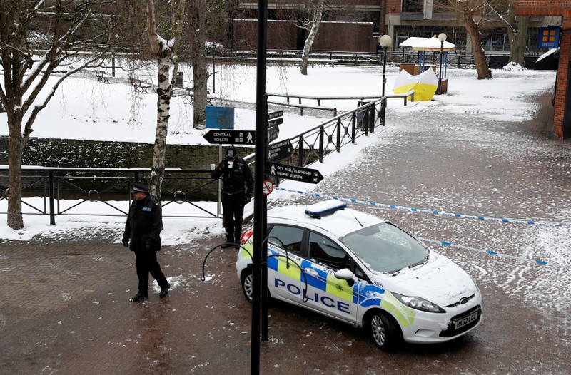 Police officers stand at the cordon near the tent covering the park bench where former Russian intelligence officer Sergei Skripal and his daughter Yulia were found poisoned in Salisbury