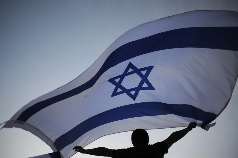 An Israeli youth waves a national flag during a rally in the coastal city of Ashkelon