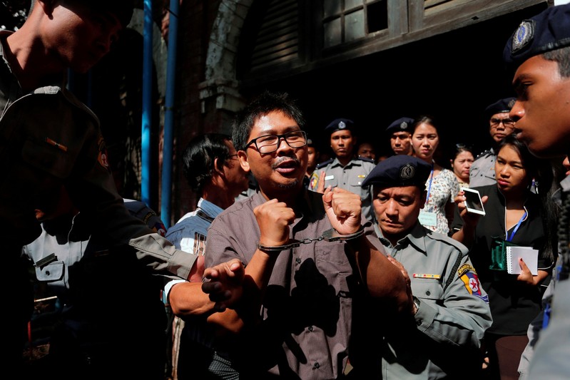 Detained Reuters journalist Wa Lone is escorted by police after a court hearing in Yangon