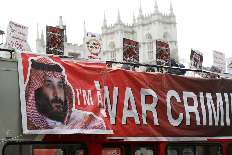 Demonstrators wave placards from an open top bus during a protest against the visit by Saudi Arabia's Crown Prince Mohammad bin Salman in central London