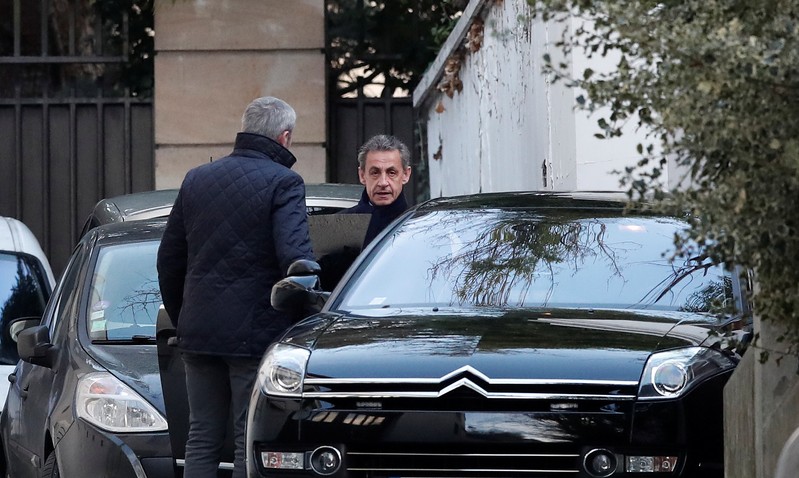 Former French President Nicolas Sarkozy enters his car as he leaves his house in Paris