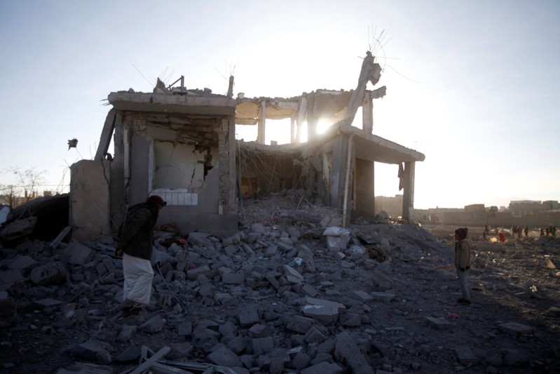 People inspect damage at the site of a Saudi-led air strike, north of Yemen's capital Sanaa