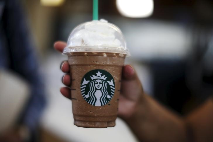 FILE PHOTO - A woman holds a Frappuccino at a Starbucks store inside the Tom Bradley terminal at LAX airport in Los Angeles