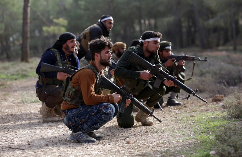 Turkish-backed Free Syrian Army fighters take up position as they advance north of Afrin