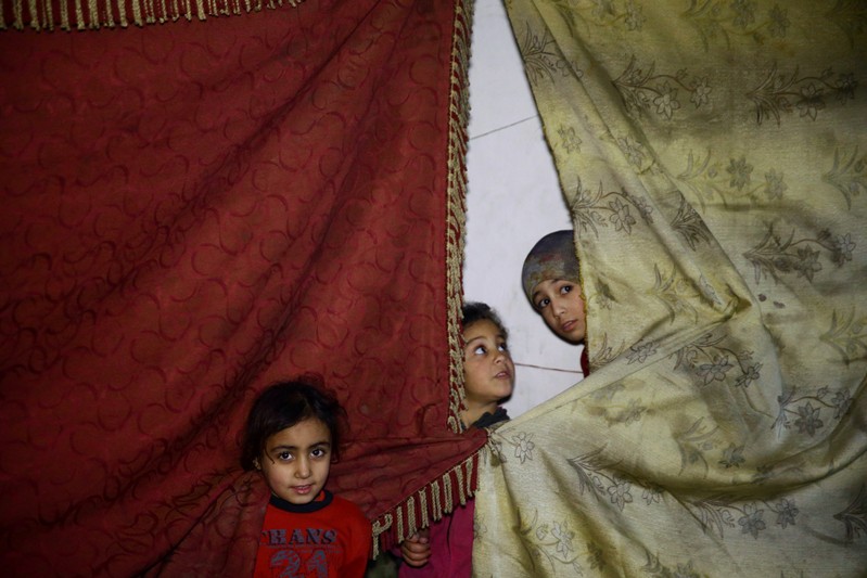 FILE PHOTO: Children stand near curtains in a shelter in the besieged town of Douma