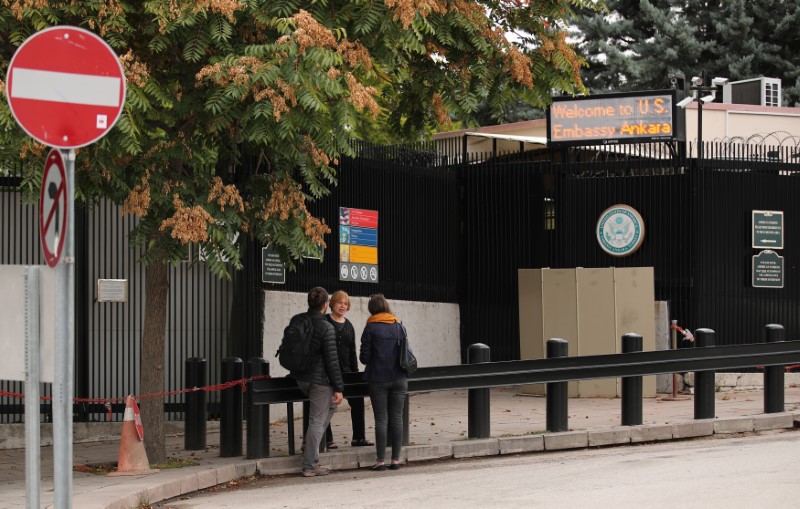 People wait in front of the visa application office entrance of the U.S. Embassy in Ankara