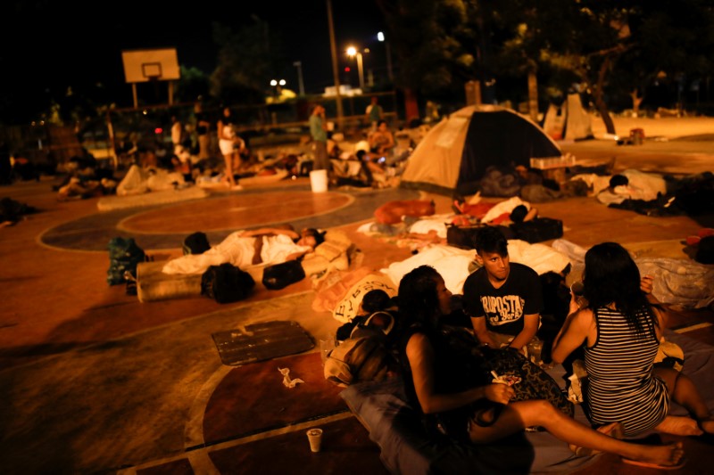 People prepare to sleep on the floor of a sport center, where a community of homeless Venezuelan migrants stays, in Cucuta