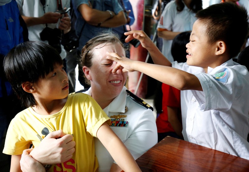 A U.S. Navy officer plays with Agent Orange victims at a hospice as part of the visit to Vietnam of U.S aircraft carrier USS Carl Vinson in Danang