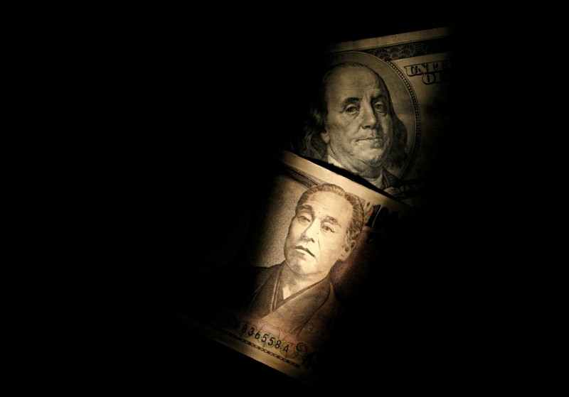 FILE PHOTO - Light is cast on U.S. one-hundred dollar bill next to Japanese 10,000 yen note
