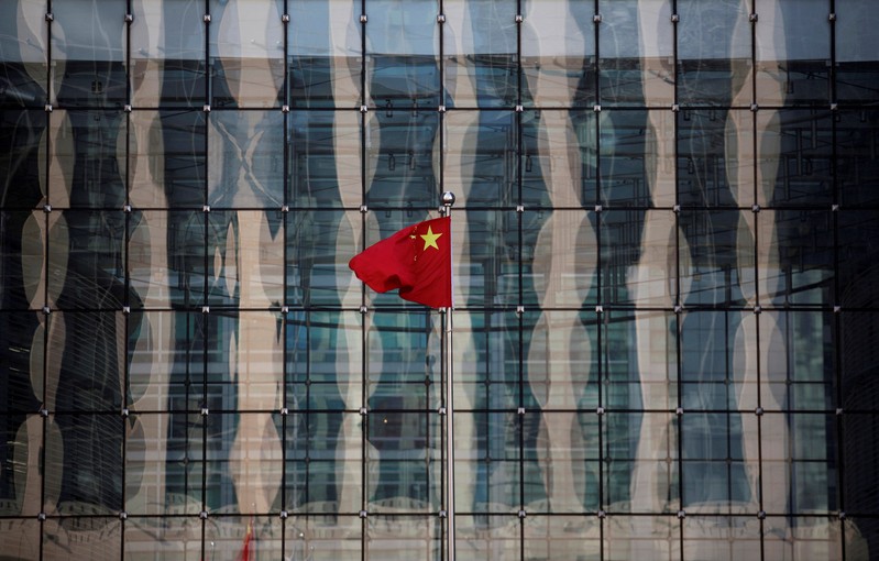 FILE PHOTO: A Chinese national flag flutters at the headquarters of a commercial bank on a financial street in central Beijing