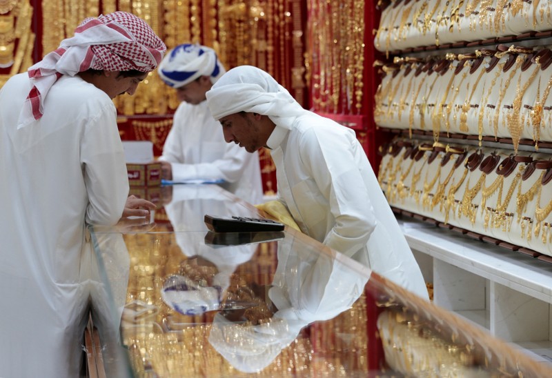 Men look at gold jewellery in a shop at the Gold Souq in Dubai