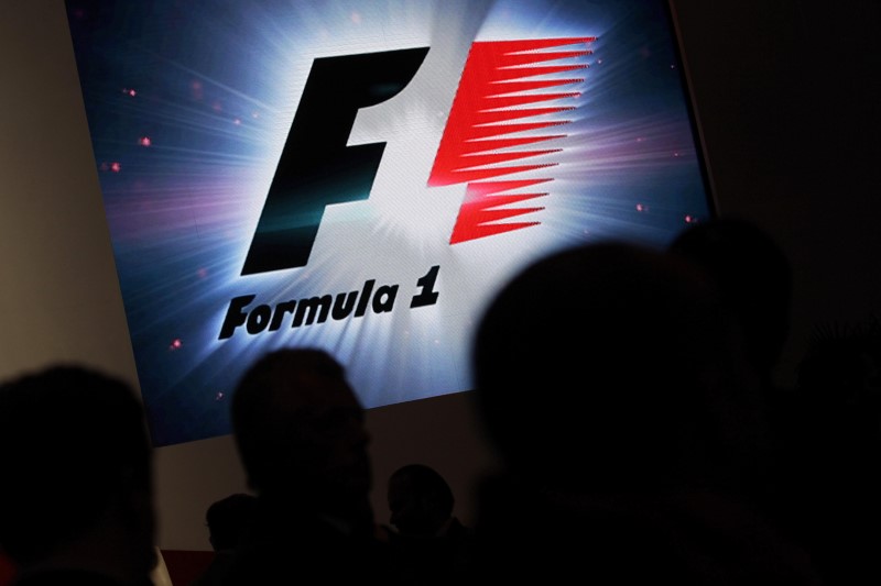 Reporters are silhouetted by a screen showing a F1 logo during a news conference to announce a Formula One race in Mexico City