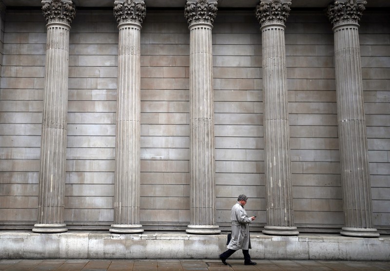 A man walks past the Bank of England in London