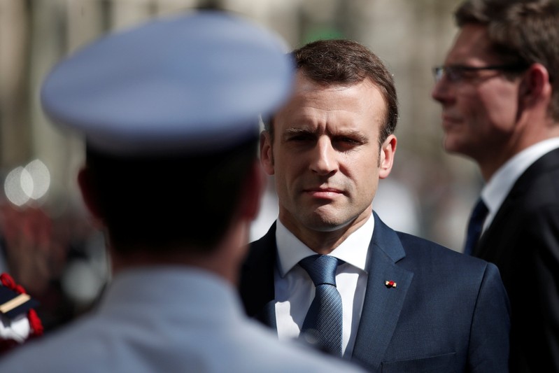 French President Emmanuel Macron attends a ceremony to pay tribute to Xavier Jugele one year after the French police officer was killed during a shooting incident, on the Champs Elysees avenue in Paris
