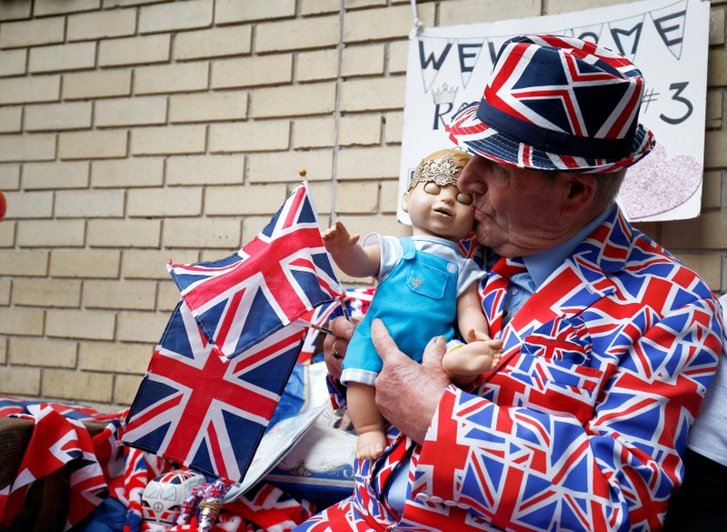 A supporter of the royal family holds a doll wearing a crown as he sits outside the Lindo Wing of St Mary's Hospital after Britain's Catherine, the Duchess of Cambridge, was admitted after going into labour ahead of the birth of her third child, in Londo