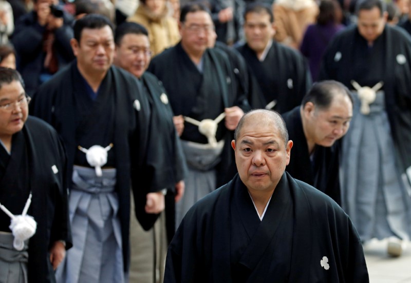 Japan Sumo Association chairman Hakkaku and sumo stable masters wearing traditional formal costumes leave after the New Year's ring-entering rite at the annual celebration for the New Year at Meiji Shrine in Tokyo