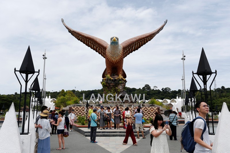 Tourists gather in front of a giant eagle sculpture at Eagle Square on Langkawi Island