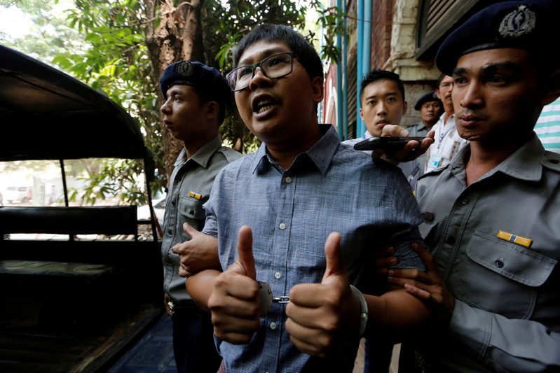 Detained Reuters journalist Wa Lone is escorted by police after a court hearing in Yangon