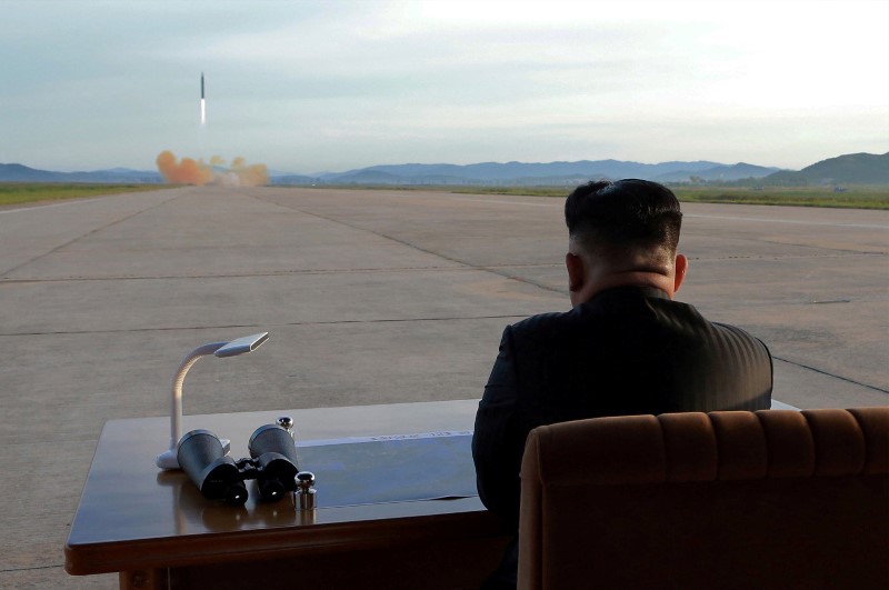 North Korean leader Kim Jong Un watches the launch of a Hwasong-12 missile in this undated photo released by North Korea's KCNA