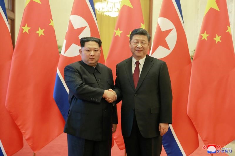 North Korean leader Kim Jong Un shakes hands with Chinese President Xi Jinping as he paid an unofficial visit to China