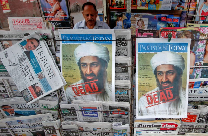 FILE PHOTO: A roadside vendor sells newspapers with headlines about the death of al-Qaeda leader Osama bin Laden, in Lahore
