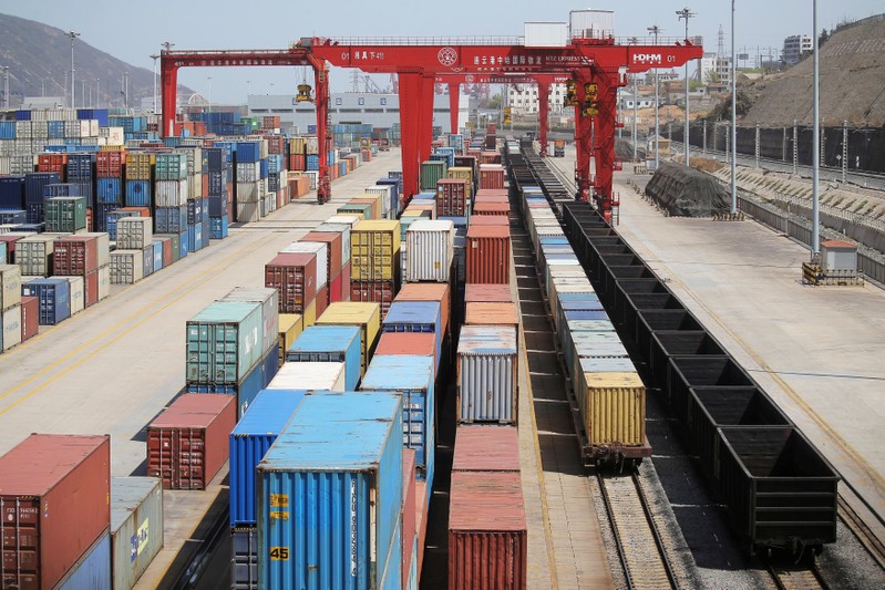 Shipping containers and train wagons are seen at a port in Lianyungang