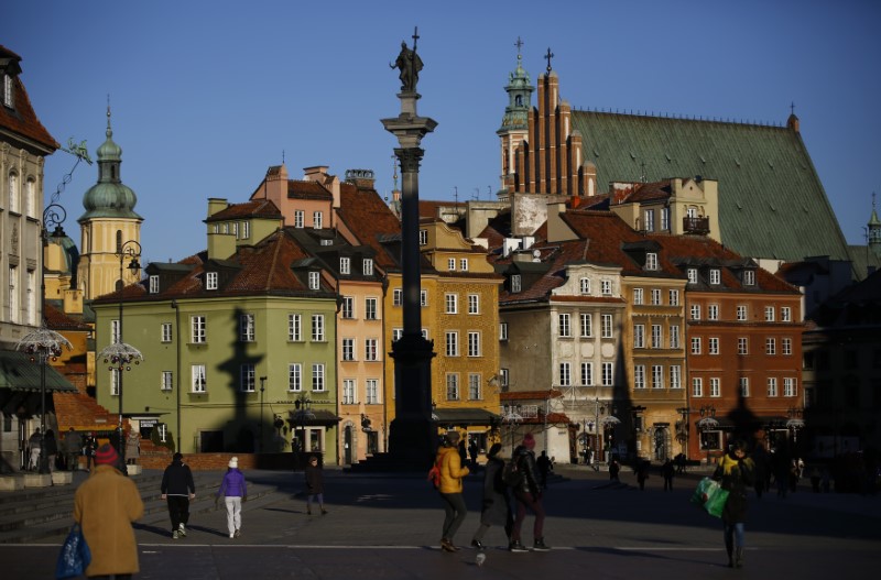 People walk in the Old Town in front of the Sigismund's Column in Warsaw
