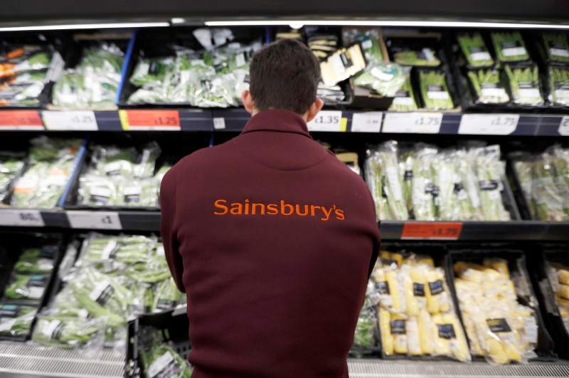 FILE PHOTO: A Sainsbury's worker stacks a vegetable shelf in a store in Redhill