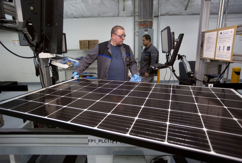 FILE PHOTO: Production operator John White checks a panel at the SolarWorld solar panel factory in Hillsboro