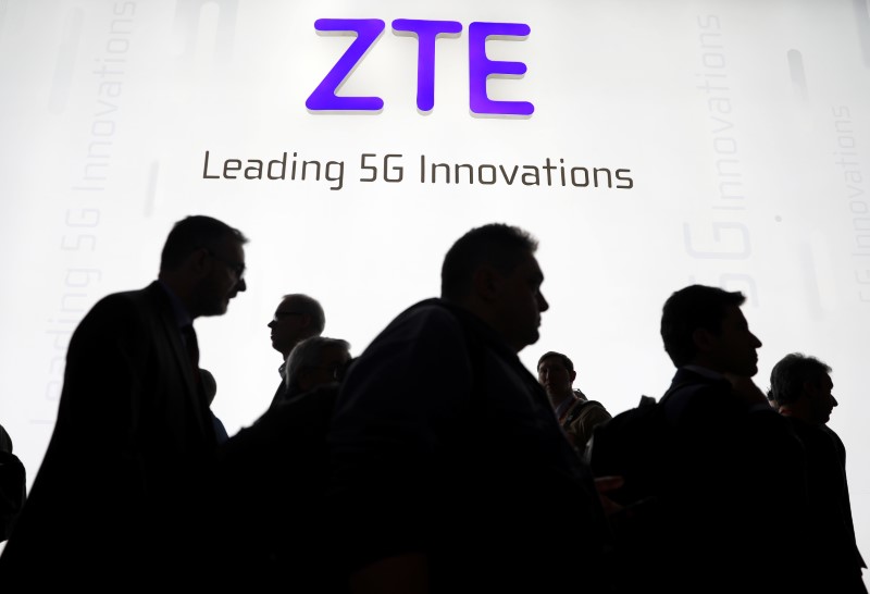 Visitors pass in front of the ZTE booth at the Mobile World Congress in Barcelona