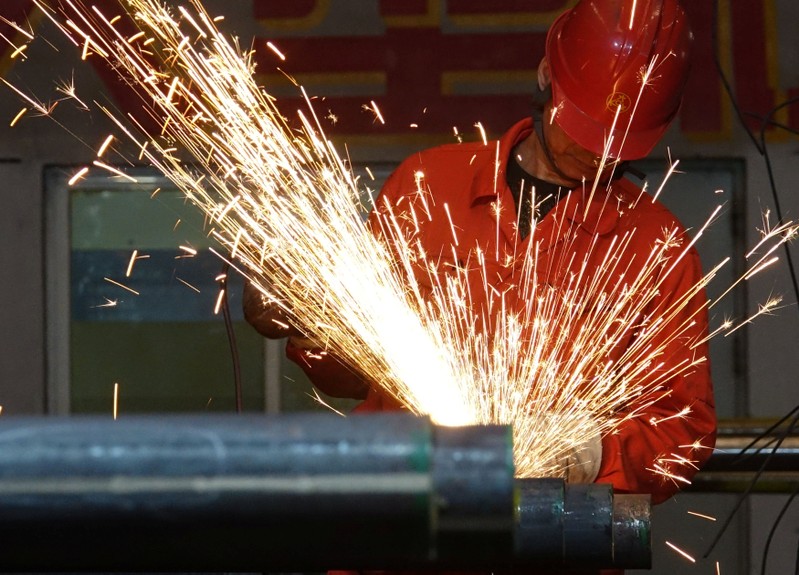 A worker polishes steel pipes at a factory of Dongbei Special Steel Group Co Ltd in Dalian