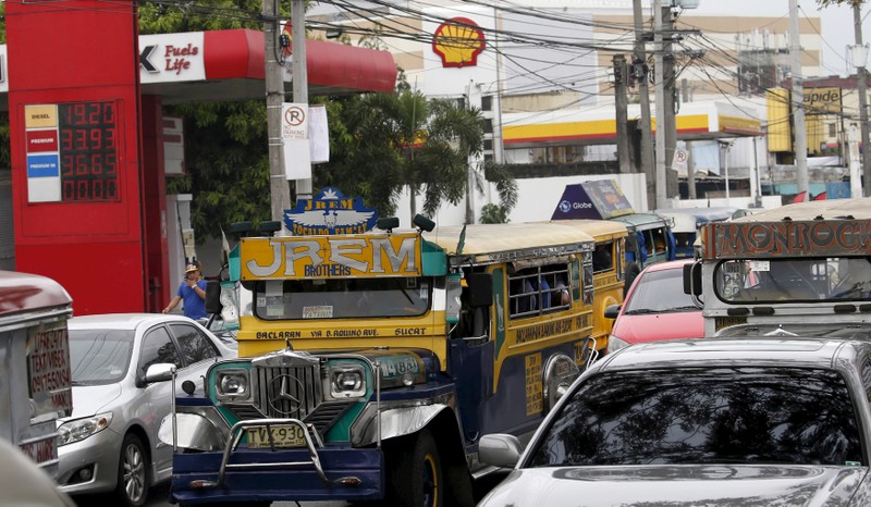 FILE PHOTO: Motorists drives past an electronic board at a gas station in Paranaque city