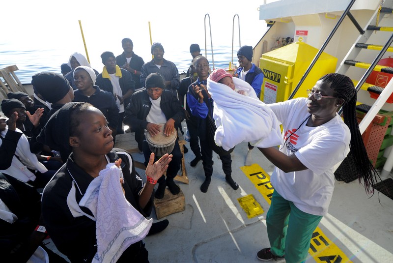 Migrants dance and sing to celebrate the birth of Miracle, a newborn baby who was born on board the Aquarius, in central Mediterranean