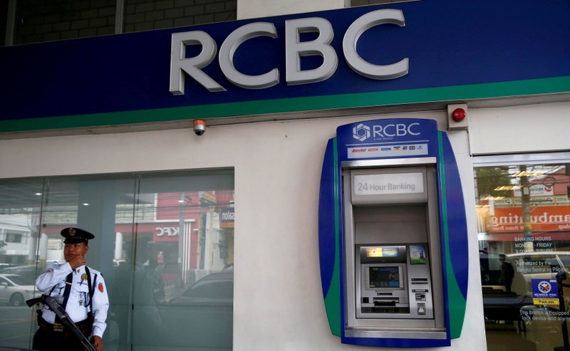 FILE PHOTO: A security guard stands guard outside a branch of Rizal Commercial Banking Corporation (RCBC) in Paranaque city, Metro Manila