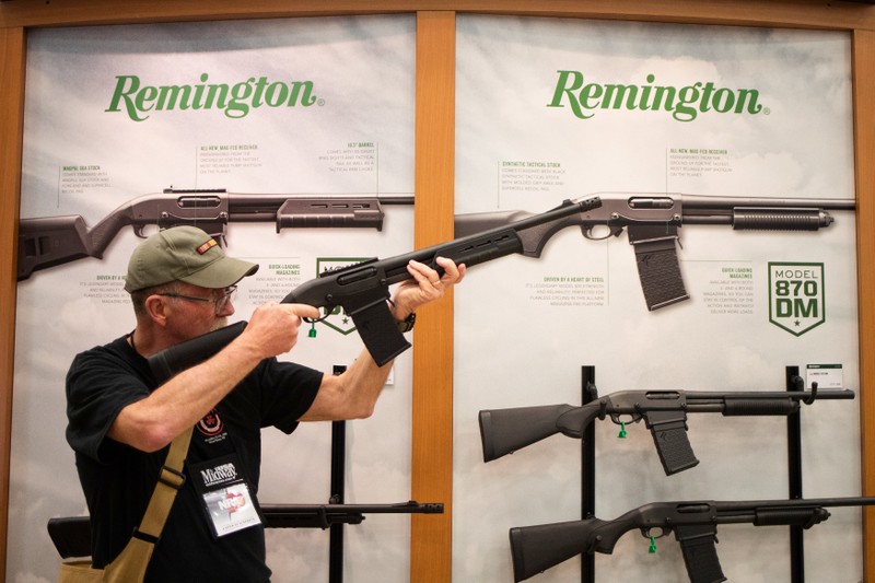 A man aims a Remington firearm at the annual NRA meeting in Dallas, Texas