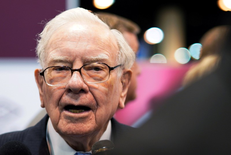 Warren Buffett, CEO of Berkshire Hathaway Inc, talks to a reporter in the exhibit hall at the company's annual meeting in Omaha