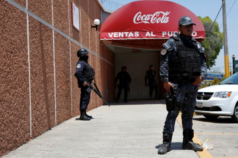 FILE PHOTO: Police officers guard the entrance of the Coca-Cola FEMSA distribution plant after it closes down due to the issues of security and violence during the campaign rally of Independent presidential candidate Margarita Zavala in Ciudad Altamirano