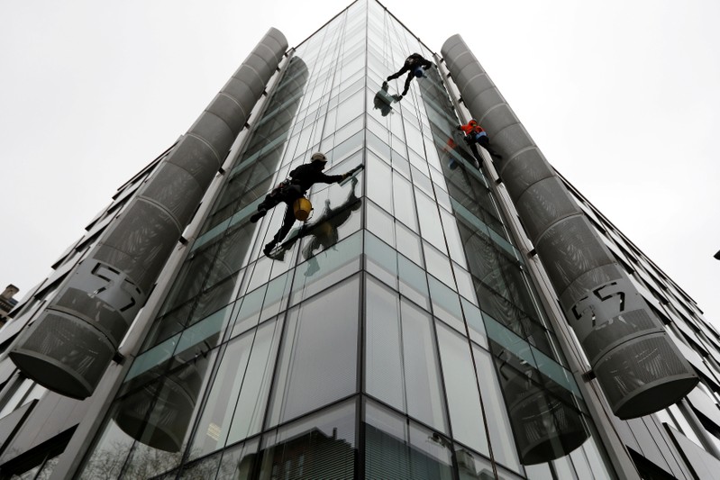 FILE PHOTO: Window cleaners work outside the offices of Cambridge Analytica in central London