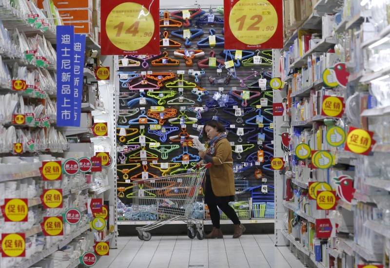 FILE PHOTO: A customer pushes a shopping cart at Sun Art Retail Group's Auchan hypermarket store in Beijing