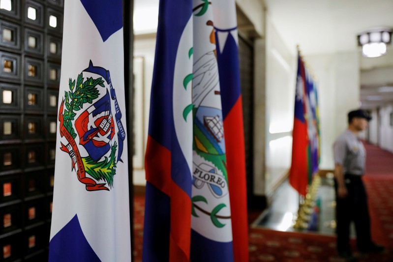 A police officer stands next to the Dominican Republic flag inside the Taiwan's Ministry of Foreign Affairs in Taipei