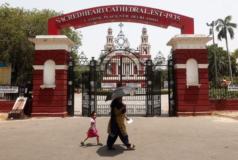 Woman and her daughter walk past the Sacred Heart Cathedral Church in New Delhi