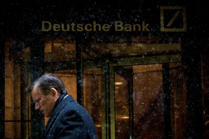 A man walks past the Deutsche Bank offices during a snow storm in Manhattan's financial district in New York