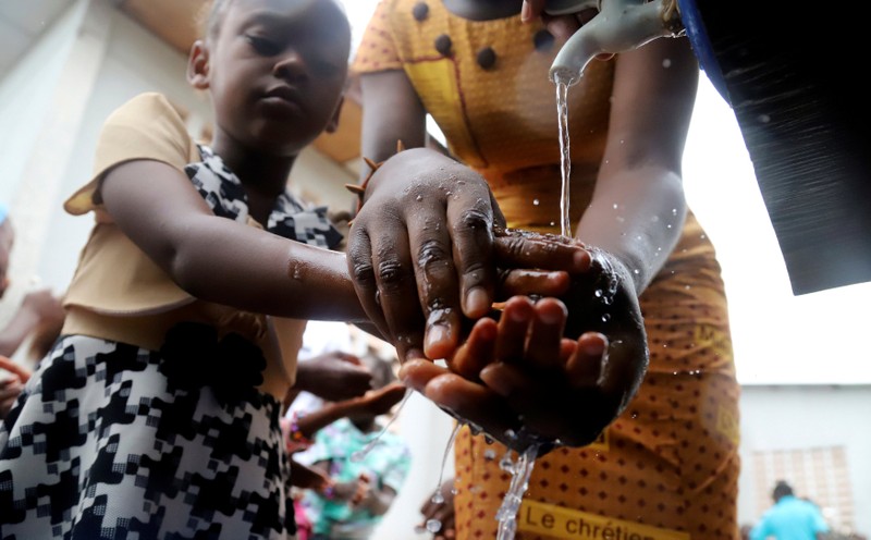 FILE PHOTO: A Congolese child washes her hands as a preventive measure against Ebola at the Church of Christ in Mbandaka