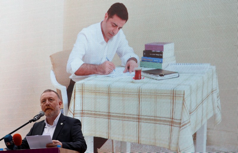 Sezai Temelli, co-leader of the pro-Kurdish HDP, speaks as a picture of Demirtas, the party's jailed former co-leader and the candidate for the upcoming presidential election, which was taken in the prison, is displayed